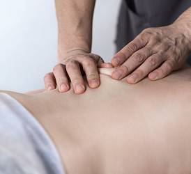 Специалист по массажу Пак Д.В. выполняет массаж спины